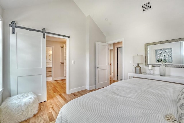 46 Pearl St, Melrose, MA 02176 - bedroom with a barn door, light wood-style flooring, and high vaulted ceiling