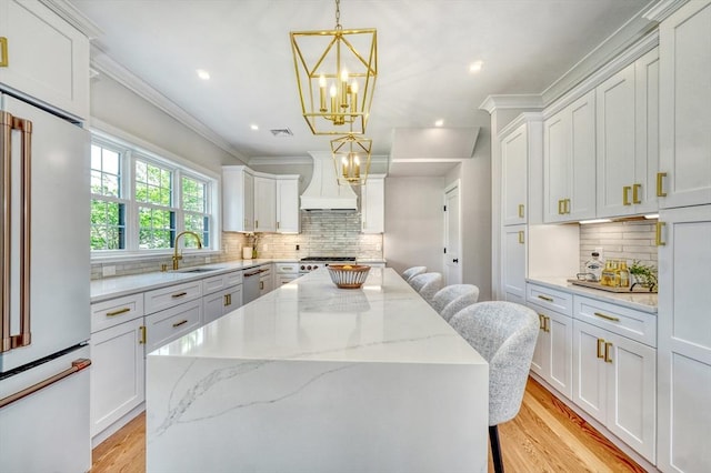46 Pearl St, Melrose, MA 02176 - kitchen with high end white fridge, custom exhaust hood, crown molding, dishwasher, and backsplash