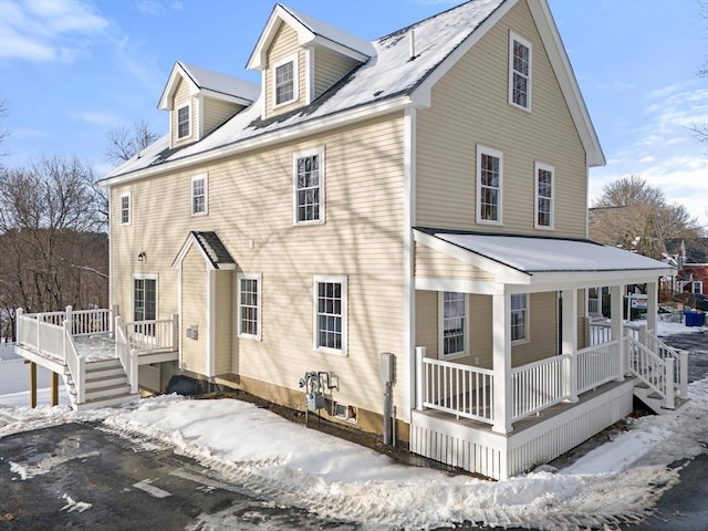 snow covered property with a porch