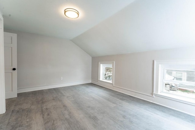 additional living space featuring baseboards, vaulted ceiling, and wood finished floors