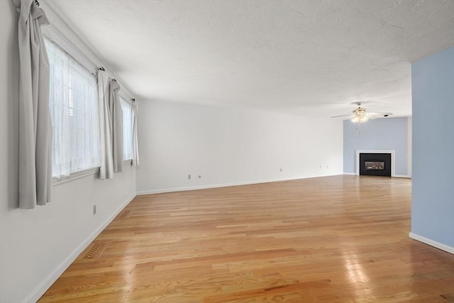 399 Pond St Unit G6, Braintree, MA 02184 - unfurnished living room with ceiling fan, light wood-style flooring, and a fireplace