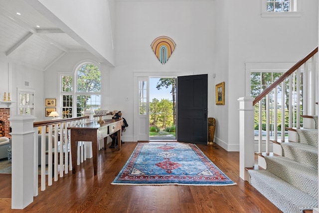 foyer entrance featuring beam ceiling, dark hardwood / wood-style floors, and high vaulted ceiling