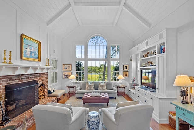 living room with light hardwood / wood-style flooring, a fireplace, beam ceiling, and high vaulted ceiling