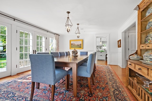 dining room with ornamental molding, light hardwood / wood-style flooring, and plenty of natural light