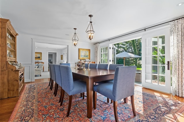 dining room with hardwood / wood-style flooring and crown molding