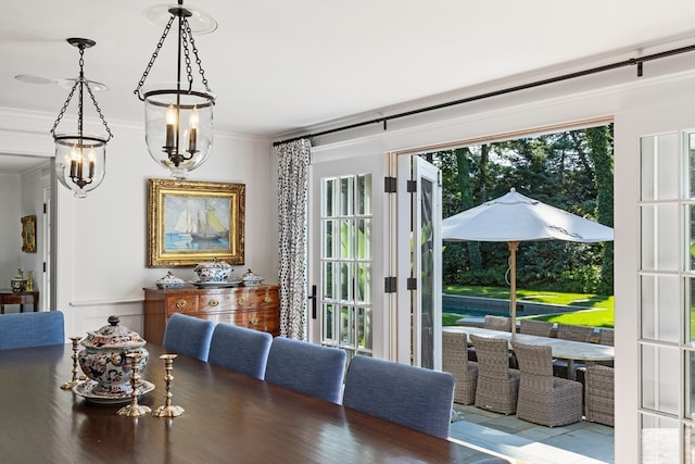 dining room with hardwood / wood-style floors, a chandelier, and ornamental molding