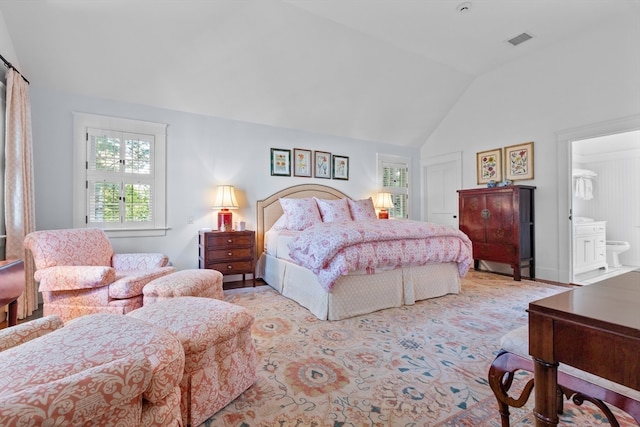 bedroom featuring lofted ceiling and ensuite bath