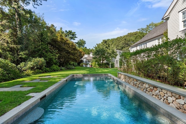 view of swimming pool with a yard