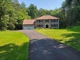 colonial-style house with a front lawn, driveway, and an attached garage