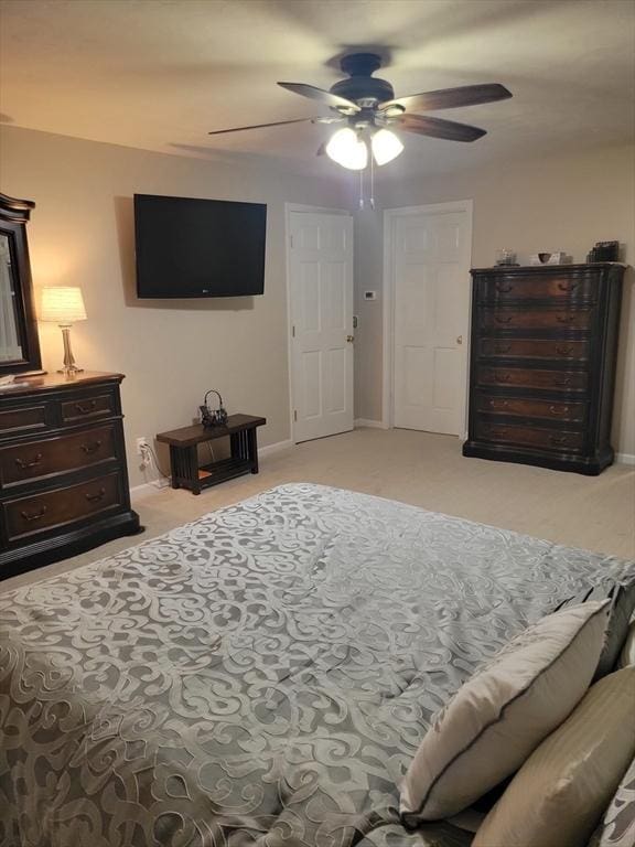 bedroom featuring light carpet, ceiling fan, and baseboards