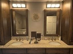 bathroom featuring a sink and double vanity