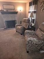 living area featuring a fireplace and carpet flooring