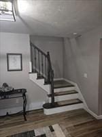 staircase featuring wood finished floors and baseboards