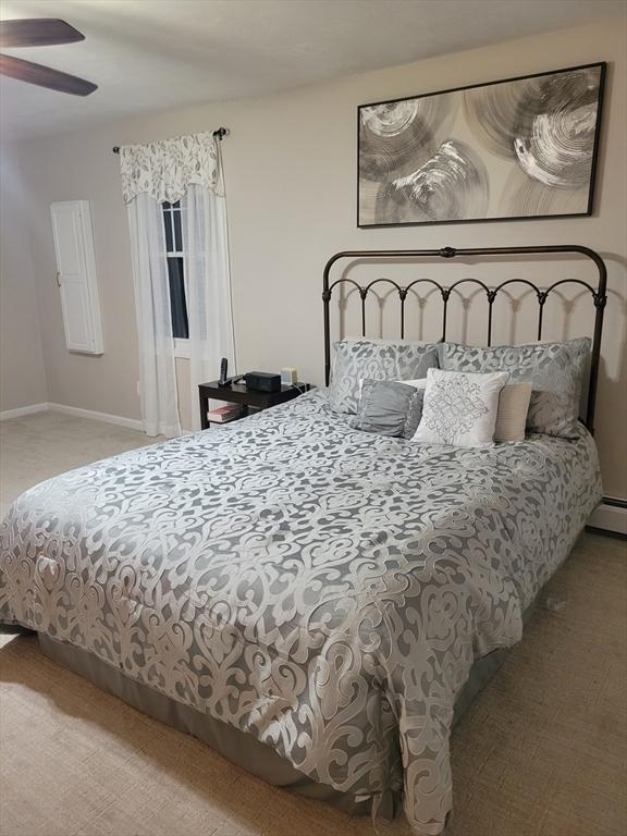 carpeted bedroom with ceiling fan and baseboards