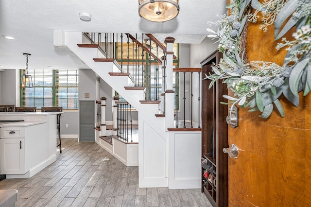 stairs featuring wood-type flooring and a textured ceiling