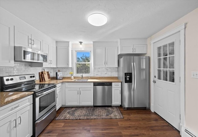 kitchen with sink, dark wood-type flooring, appliances with stainless steel finishes, white cabinets, and a baseboard radiator