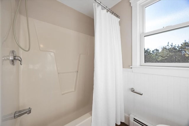 bathroom with a baseboard radiator, a wealth of natural light, and shower / bath combo