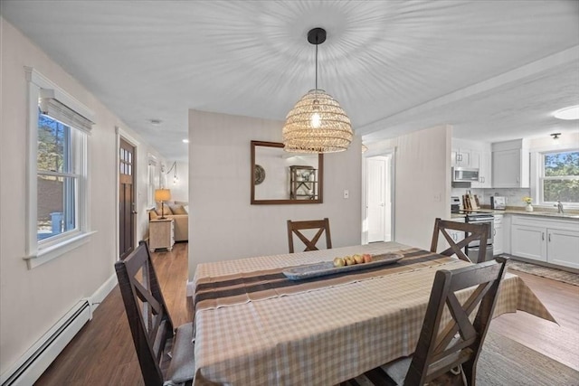 dining room with hardwood / wood-style flooring, sink, and baseboard heating