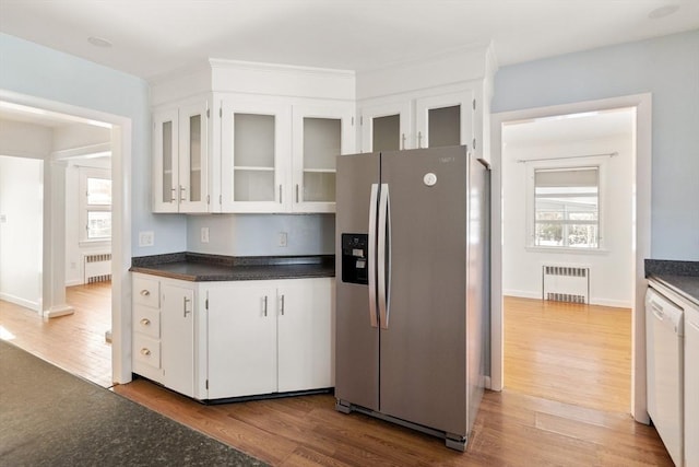 kitchen with stainless steel fridge with ice dispenser, white cabinetry, and radiator