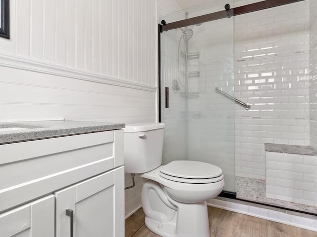 bathroom with wood-type flooring, toilet, walk in shower, and vanity