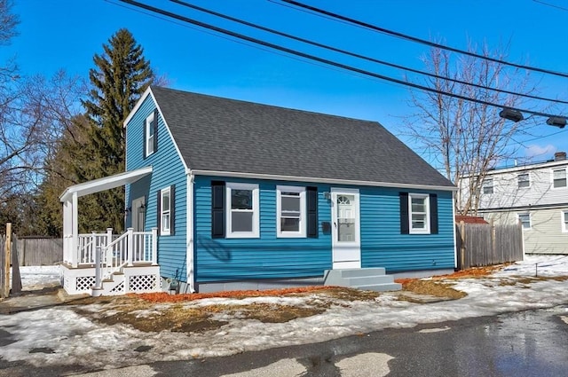 view of front of home with a shingled roof and fence