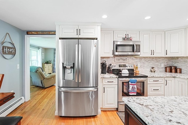 14 Daniels Rd, Charlton, MA 01507 - kitchen featuring appliances with stainless steel finishes, baseboard heating, light stone countertops, white cabinetry, and recessed lighting