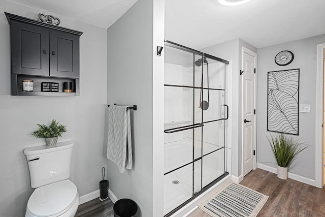 14 Daniels Rd, Charlton, MA 01507 - bathroom with wood finished floors, a stall shower, baseboards, and toilet
