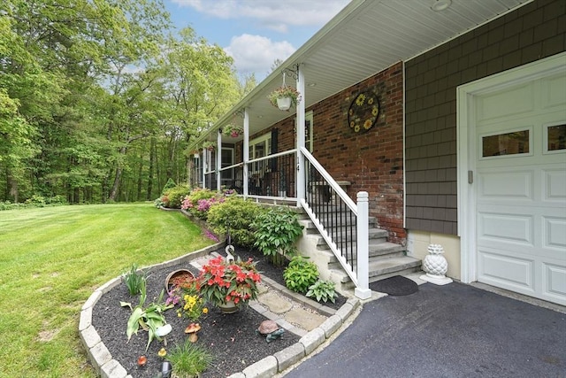 14 Daniels Rd, Charlton, MA 01507 - entrance to property with a porch, a lawn, driveway, brick siding, and an attached garage