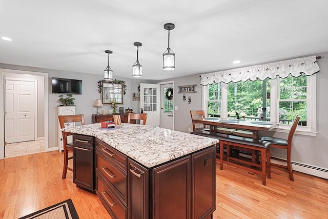 14 Daniels Rd, Charlton, MA 01507 - kitchen with light wood finished floors, pendant lighting, a kitchen island, light stone counters, and dark brown cabinets