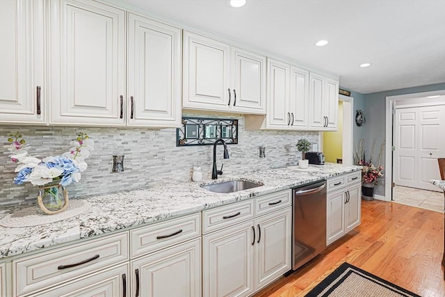 14 Daniels Rd, Charlton, MA 01507 - kitchen featuring stainless steel dishwasher, a sink, white cabinetry, light wood finished floors, and decorative backsplash