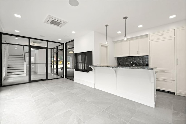 210 Monument Farm Rd, Concord, MA 01742 - kitchen with white cabinets, light tile patterned floors, visible vents, and dark stone counters