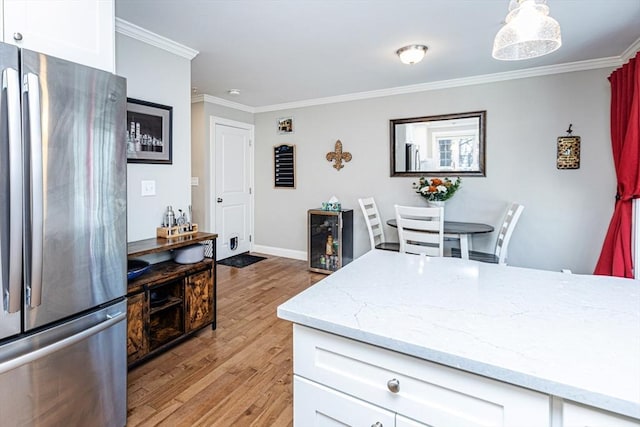 kitchen featuring crown molding, light wood-style flooring, white cabinets, and freestanding refrigerator