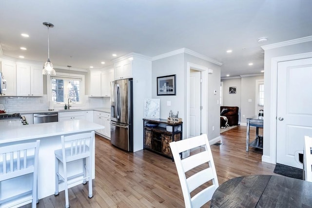 kitchen with backsplash, dark wood finished floors, light countertops, appliances with stainless steel finishes, and white cabinets