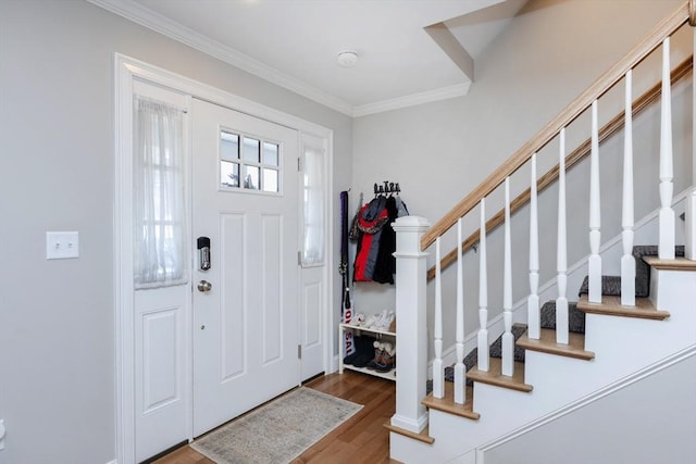 foyer with stairs, wood finished floors, and ornamental molding