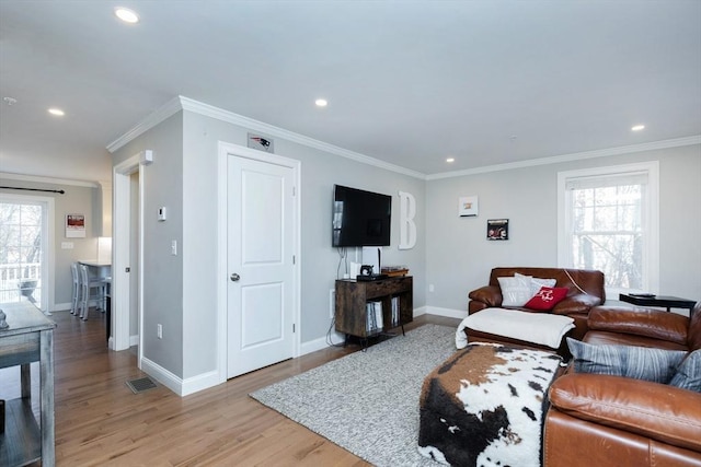 living room with crown molding, recessed lighting, light wood-style floors, and a wealth of natural light