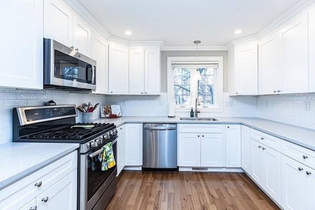 kitchen featuring white cabinets, stainless steel appliances, and a sink