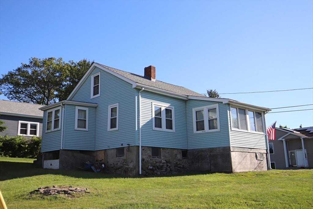 23 Bay View Rd, Saugus, MA 01906 - view of home's exterior featuring a chimney and a lawn