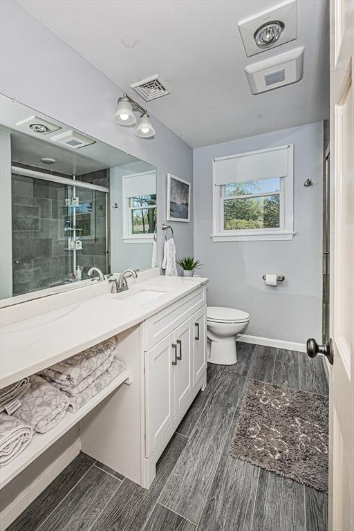 27 Ann St, Raynham, MA 02767 - bathroom with vanity, a shower stall, wood finish floors, and plenty of natural light