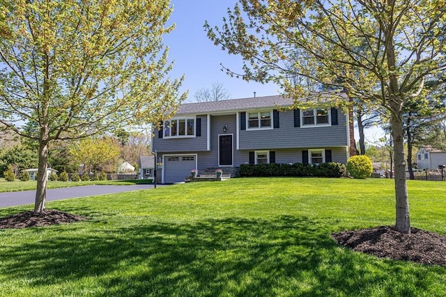27 Ann St, Raynham, MA 02767 - split foyer home featuring driveway, an attached garage, and a front yard