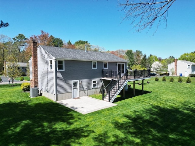 27 Ann St, Raynham, MA 02767 - back of property featuring a deck, a patio, a lawn, and a chimney