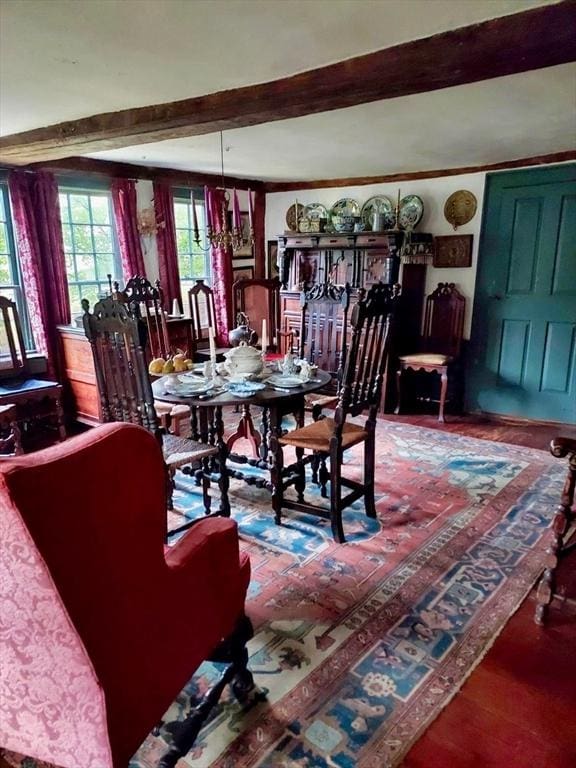 dining area with crown molding, wood finished floors, and beamed ceiling