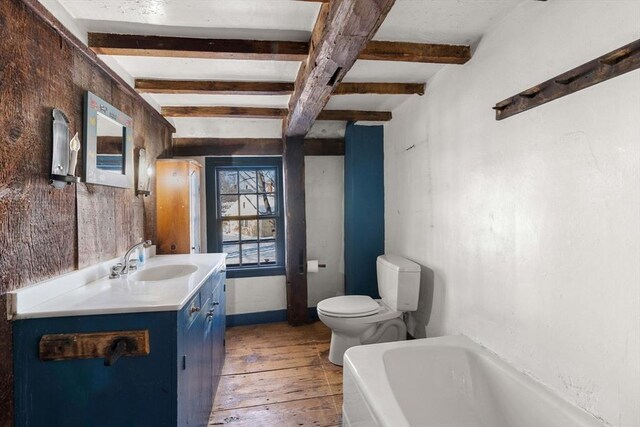 full bathroom featuring a tub, wood-type flooring, beamed ceiling, and vanity