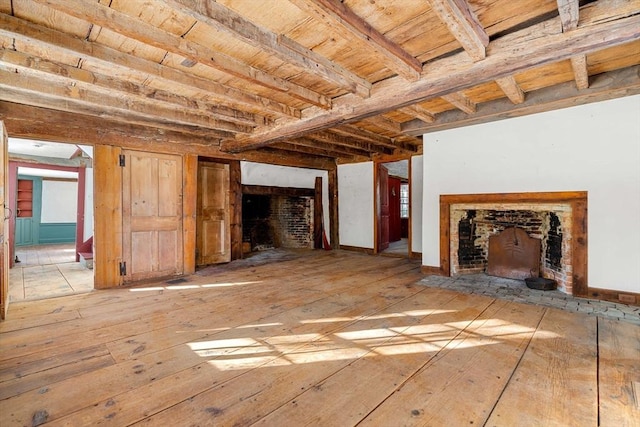 unfurnished living room featuring wooden ceiling, a fireplace, and beamed ceiling