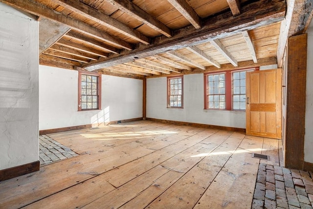 unfurnished room featuring wood ceiling, light wood-style flooring, visible vents, and baseboards