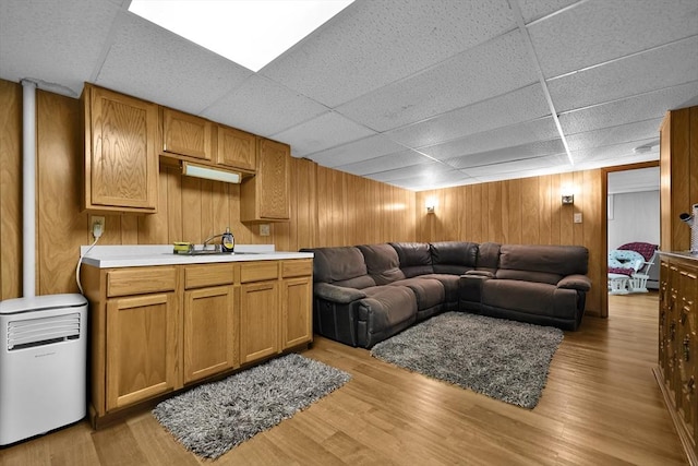 313 Walter St, Fall River, MA 02724 - living room with a paneled ceiling, wooden walls, and light wood-type flooring