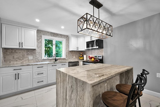 313 Walter St, Fall River, MA 02724 - kitchen with stainless steel appliances, light marble finish floors, light stone counters, backsplash, and white cabinetry