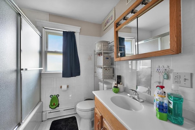 313 Walter St, Fall River, MA 02724 - bathroom featuring a baseboard heating unit, tile walls, vanity, tile patterned floors, and enclosed tub / shower combo
