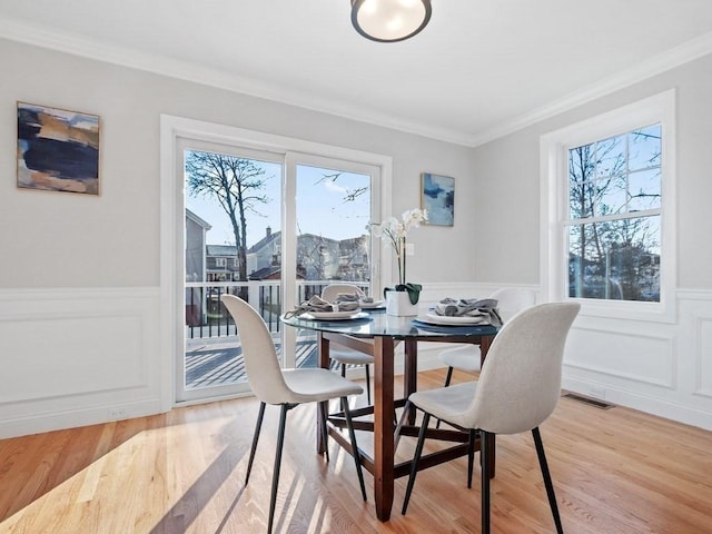 dining room with wood-type flooring and crown molding