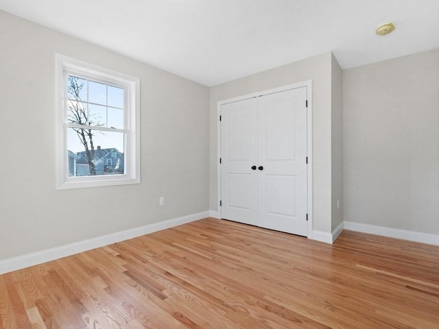 unfurnished bedroom with a closet and light hardwood / wood-style flooring