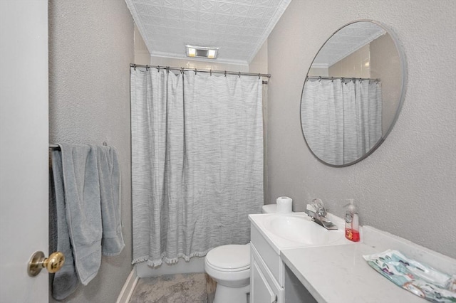 bathroom featuring a textured wall, ornamental molding, vanity, and toilet